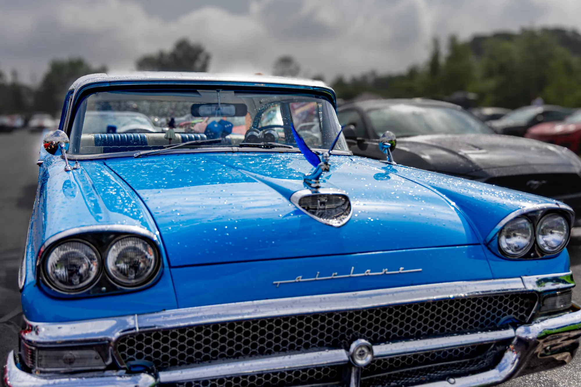 Zweifarbiger blau-weißer Ford Fairlane 500 der späten 1950er mit Continental-Heckflossen und Interstate-Drag-Day-Plakette 69, im Innenraum hängen Flauschwürfel am Rückspiegel.